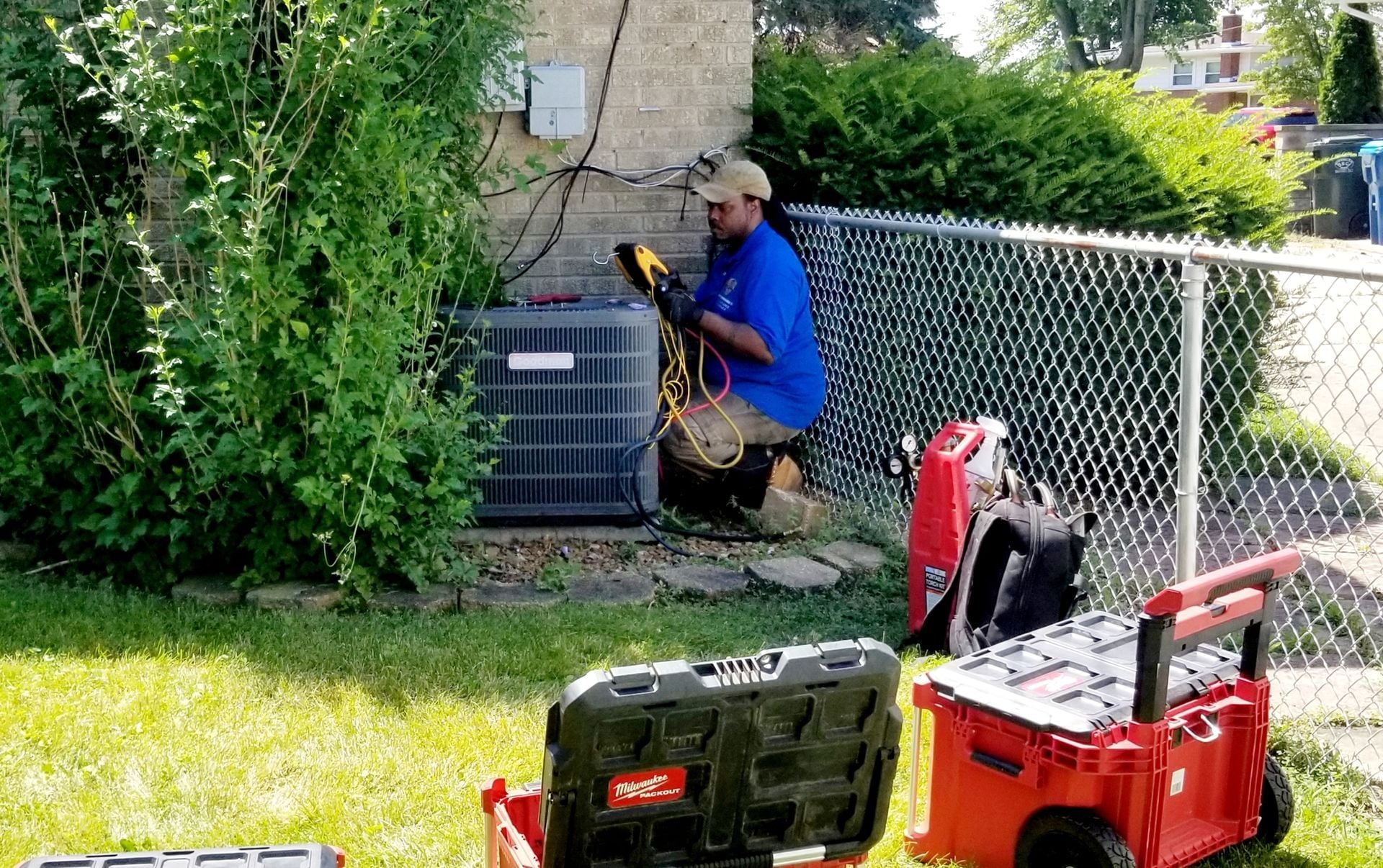 Direct Improvements technician servicing a residential outdoor condenser