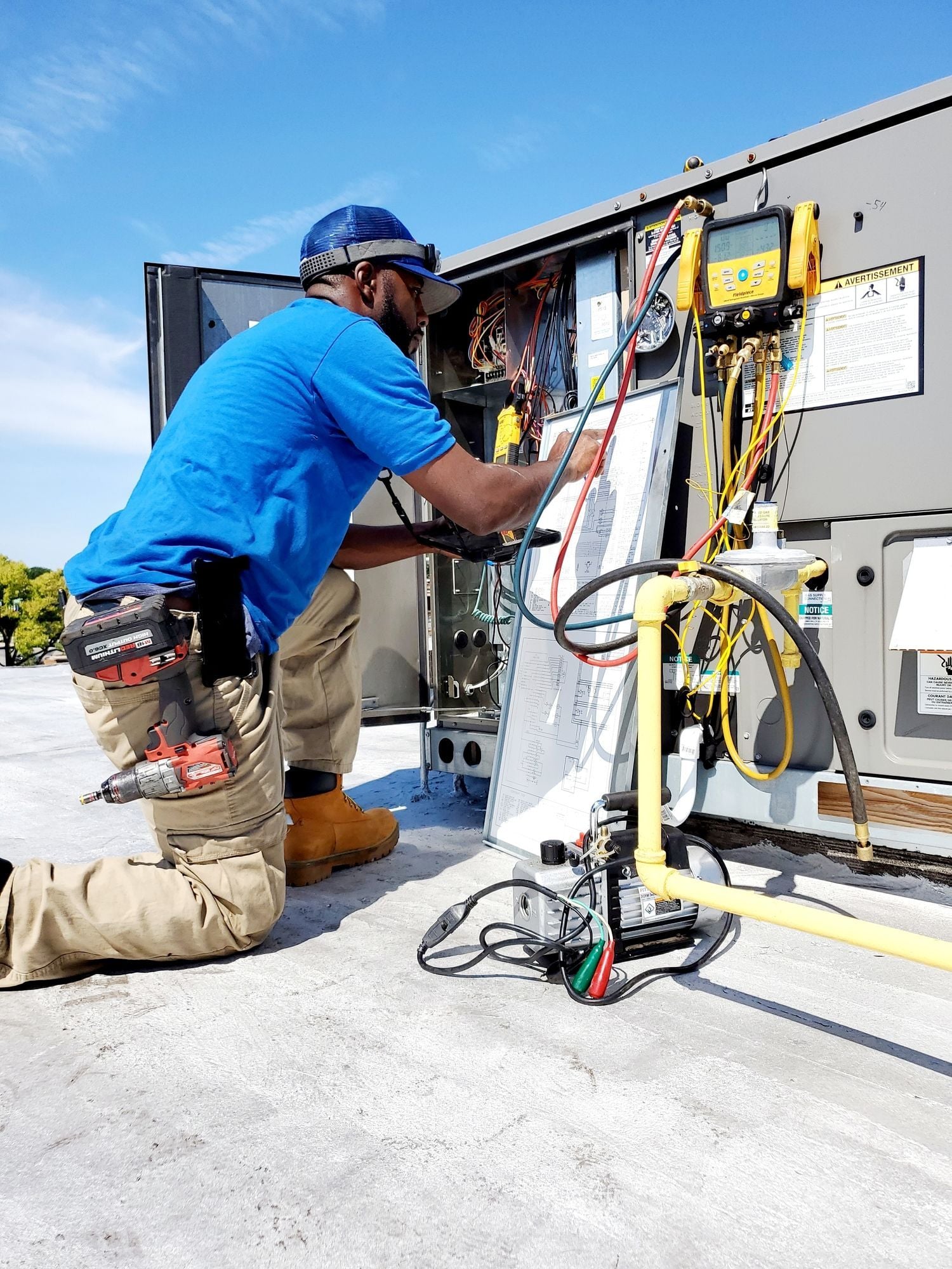 Technician using manifold gauges to diagnose an HVAC system