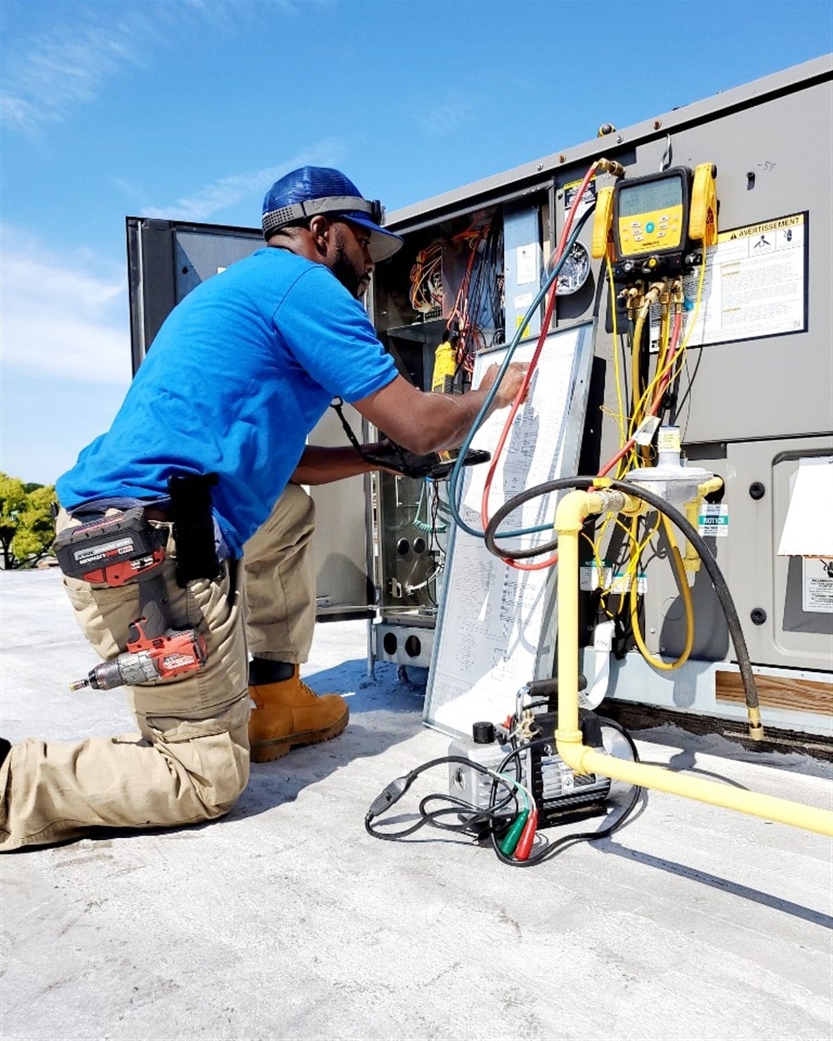 Direct Improvements HVAC technician diagnosing a commercial rooftop heating and cooling system.