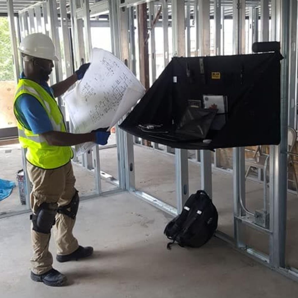 Technician reviewing plans during an active building renovation
